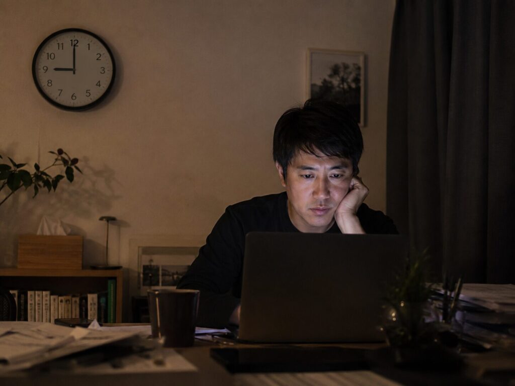 夜遅くまでひとりで仕事を続ける男性